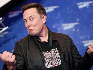 white man(elon musk) with hands apart and thumbs out