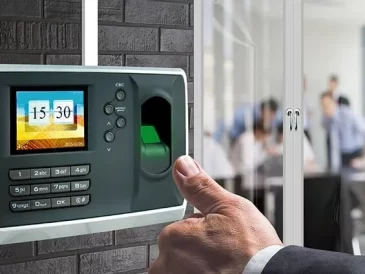 thumb of man in front of time and access control device