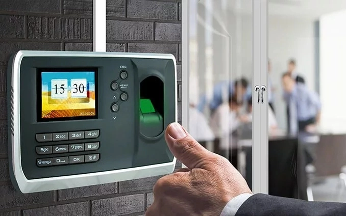 thumb of man in front of time and access control device
